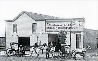 Cascade Livery Roduck Bros. Prop. with two horse drawn buggies and several people in front