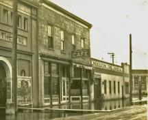 Sepia toned image of two of the buildings which make up the Murk Block. One has a brick facade and the other has a concrete facade.