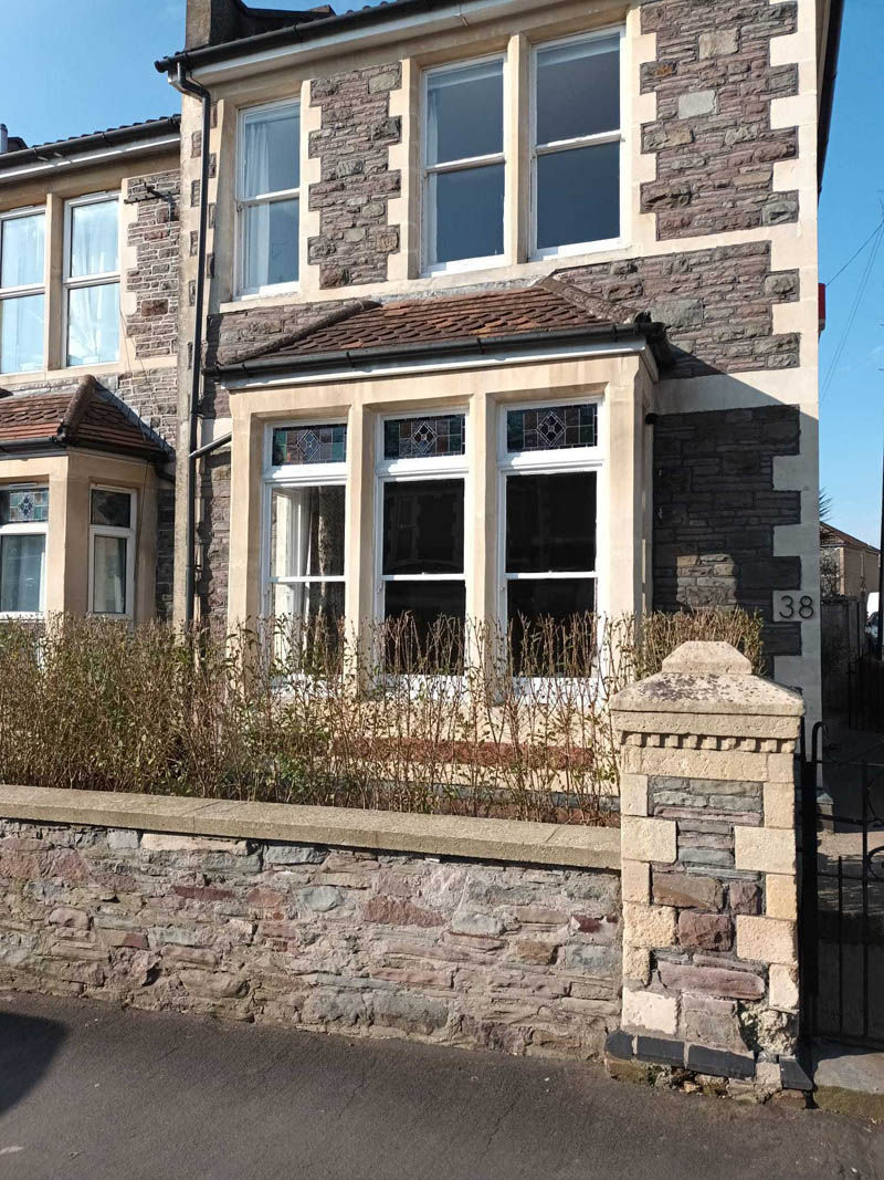 The original frontage, with ageing sash windows and stained glass upper sections.