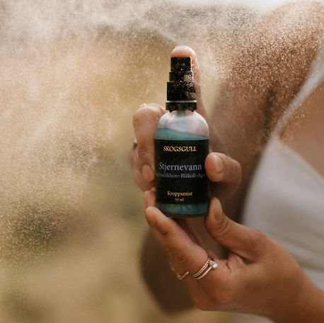 Produktfoto av flaske holdt i hånden i naturlig lys