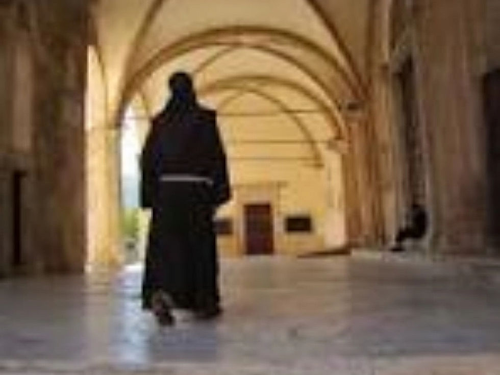 A Franciscan priest standing in the hallway of the church