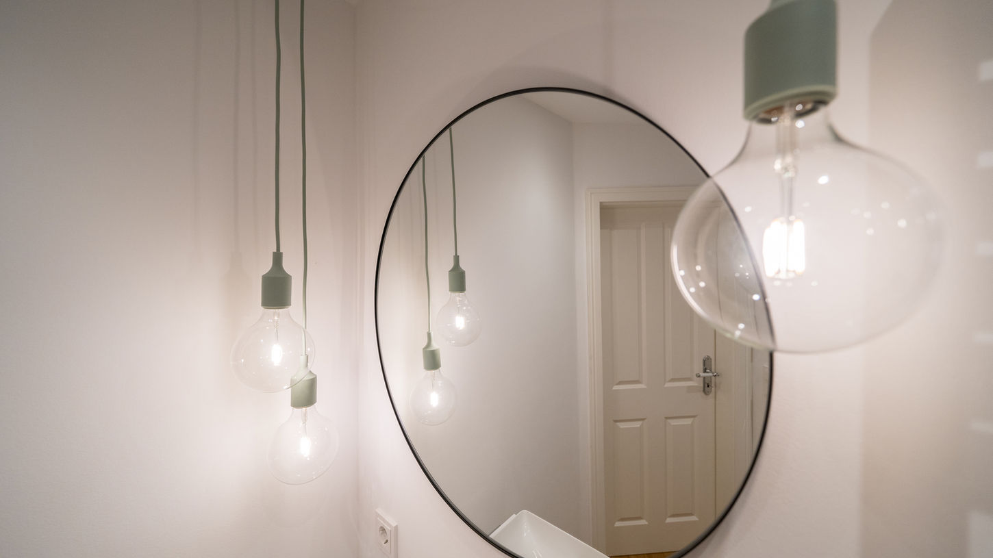 Ansicht runder Spiegel und Leuchten im Duschbad Bergstedt