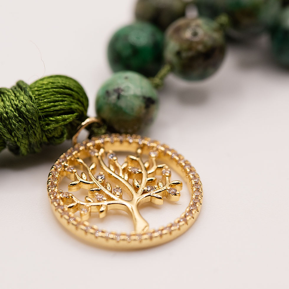 Detailaufnahme des vergoldeten Lebensbaum-Anhängers der Enchanted Woodland Mala Kette aus Afrikanischem Türkis und Lavastein.