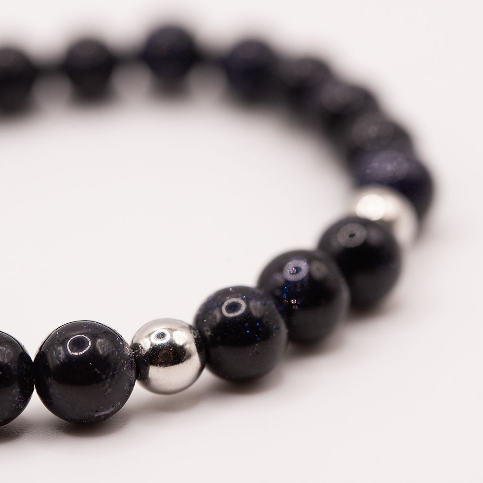 Miniaturbild: Detailansicht dunkelblauer Glitzerperlen mit silberfarbenen Akzenten an einem Perlenarmband.