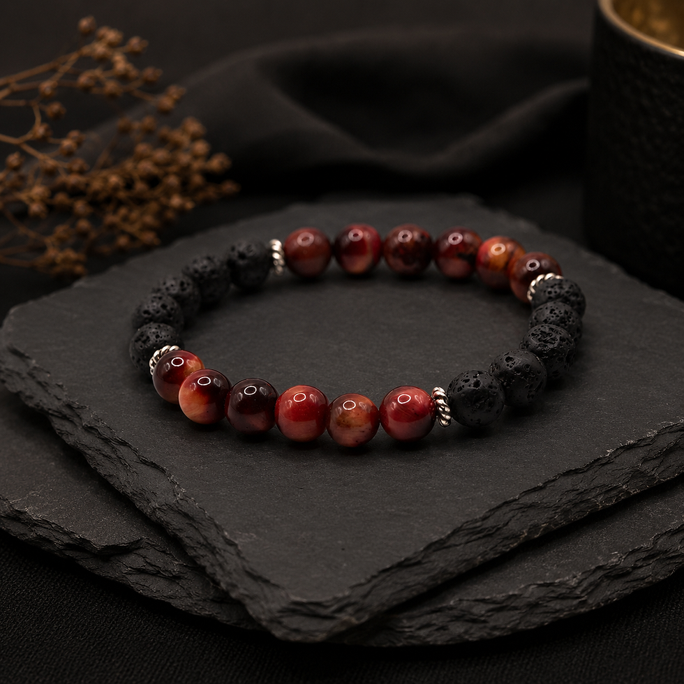 Edelsteinarmband aus rotem Tigerauge und Lavastein auf dunklen Schieferplatten vor schwarzem Hintergrund.