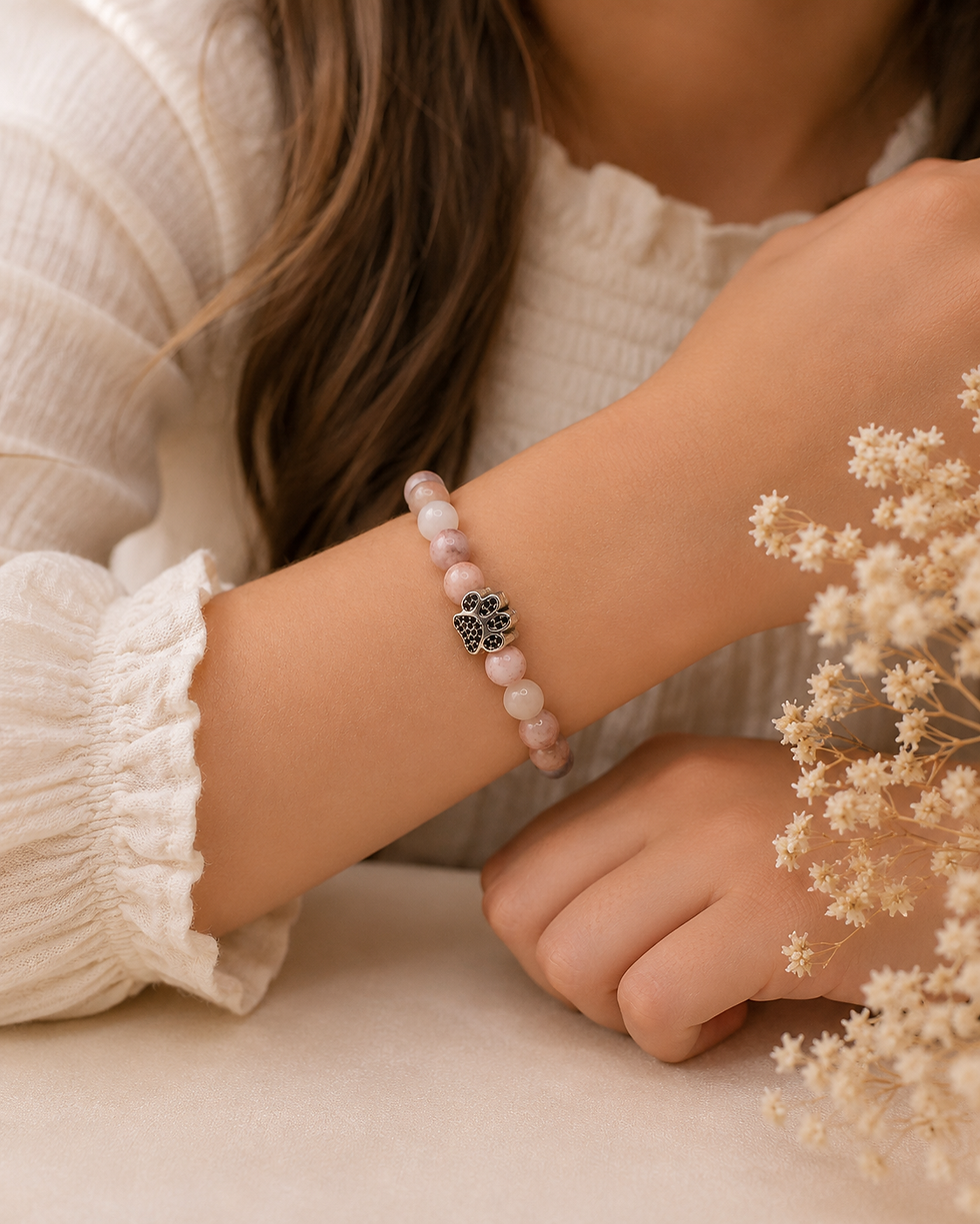Mädchen trägt das Guardian Paws Kinder Edelsteinarmband mit Mondstein und Pink Zebra Jaspis am Handgelenk.