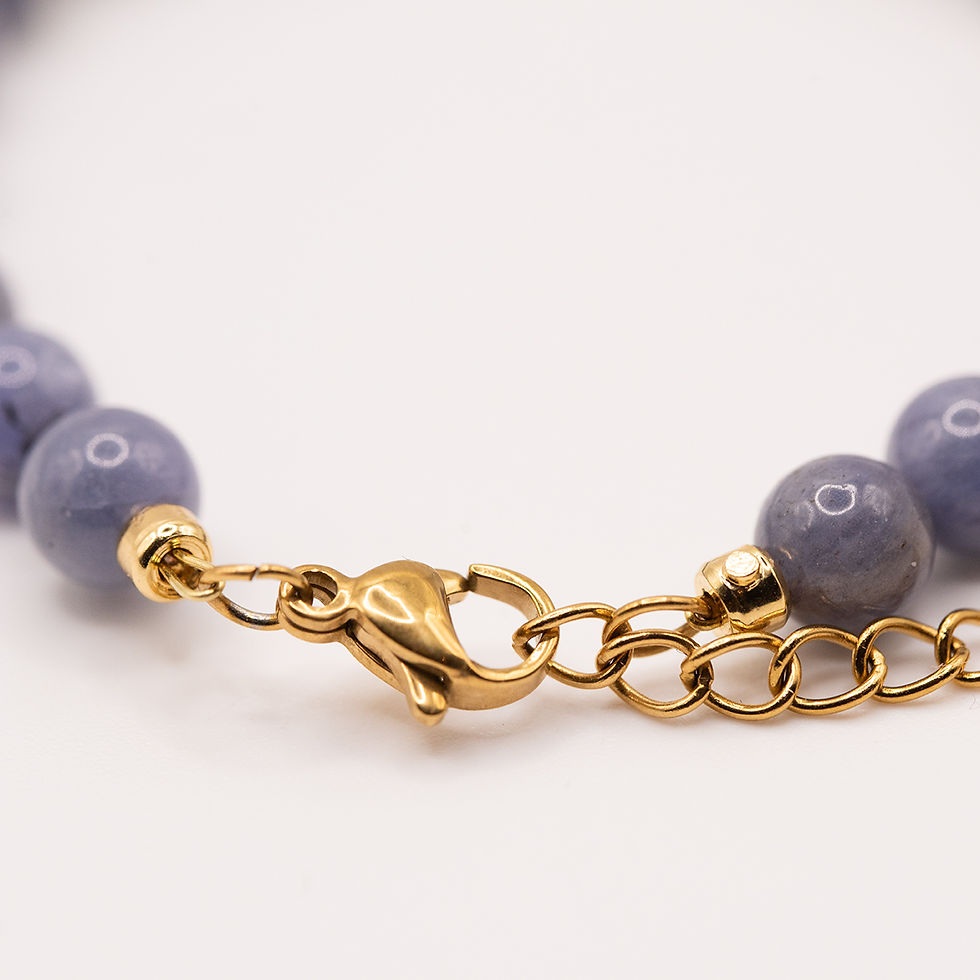 Thumbnail: Makroaufnahme des vergoldeten Edelstahlverschlusses des Edelsteinarmbands mit Tansanit und Süsswasserperle.