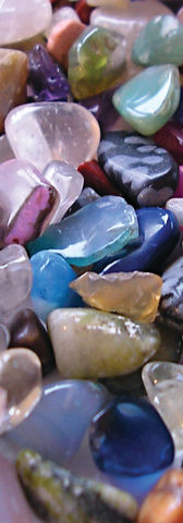 The tumbled gemstones vary in size and shape, with some being round and others more angular. The colors are diverse, ranging from deep pinks to bright yellows, rich greens, and vibrant blues. Some of the gems have multiple colors and patterns swirling together, creating an almost hypnotic effect.

As the gems are piled on top of each other, they create a stunning contrast of colors and textures. The smooth surfaces of the stones make them pleasant to touch and handle, and they feel cool to the touch.