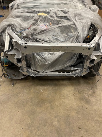 welded on core support, front end of silver sedan