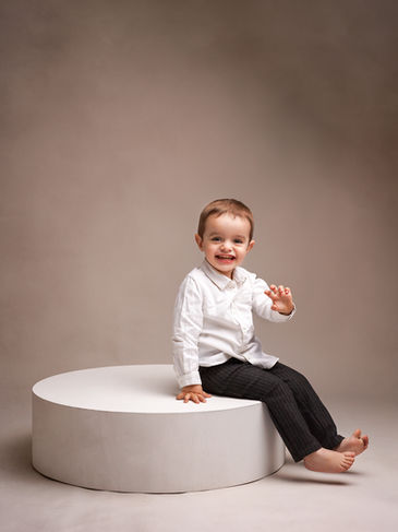 Photographe enfant Yvelines - portrait souriant sur socle blanc