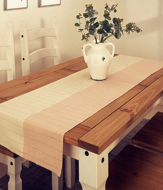Mesa de madera con corredor, jarrón blanco y sillas. solferinoweb