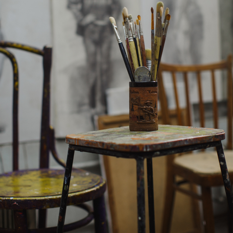 Pinceles y brochas en un envase sobre una mesa pintada; solferinoweb.