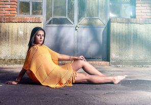Mujer joven en vestido naranja posando al aire libre, solferinoweb.
