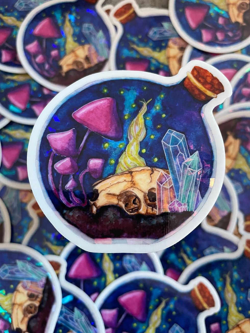 A sparkly sticker of a rounded jar with a rat skull, mushrooms and crystals inside