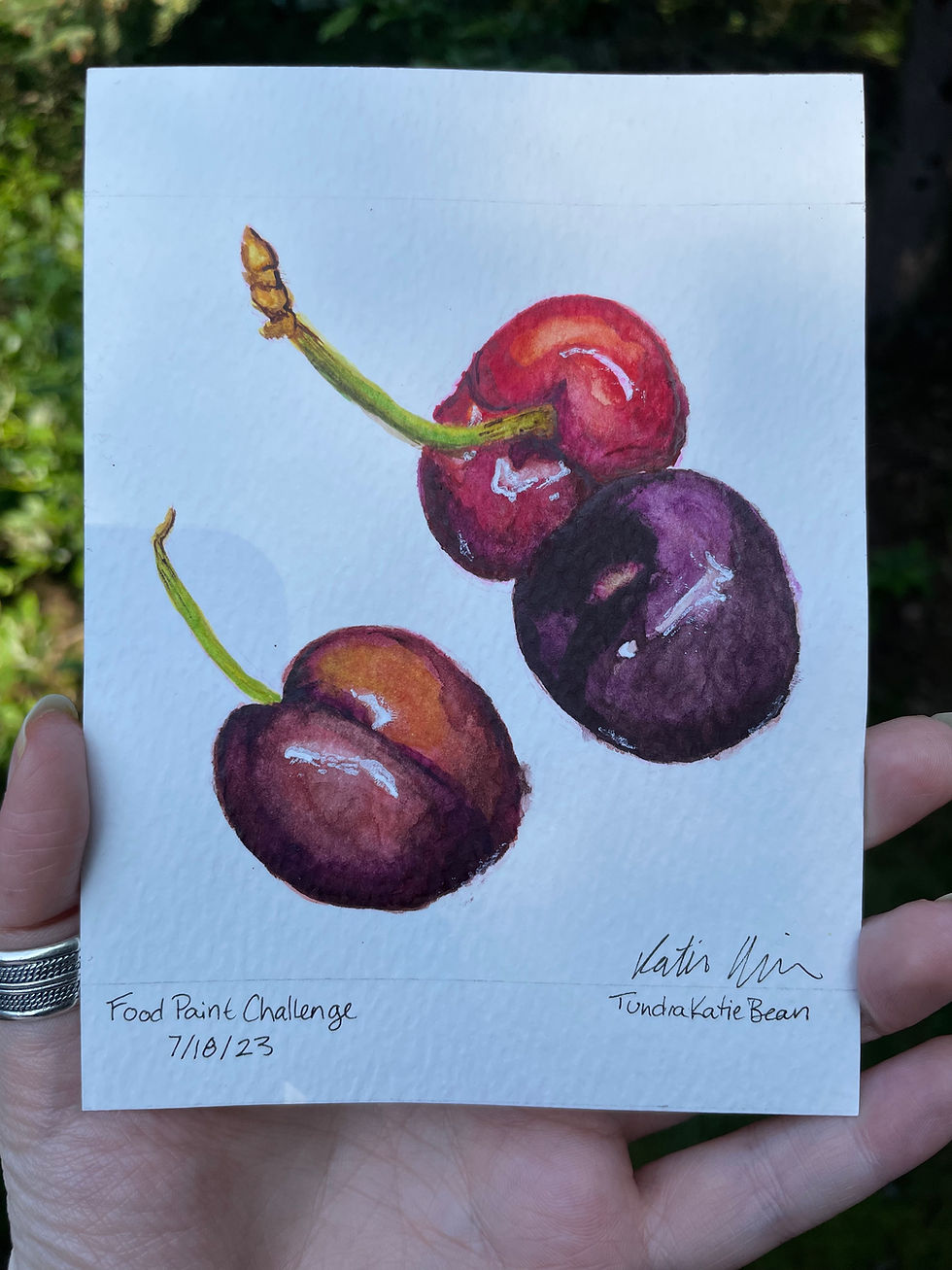 A painting of three cherries