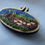 Thumbnail: An embroidered picture of a mossy log with mushrooms held in a small wooden hoop