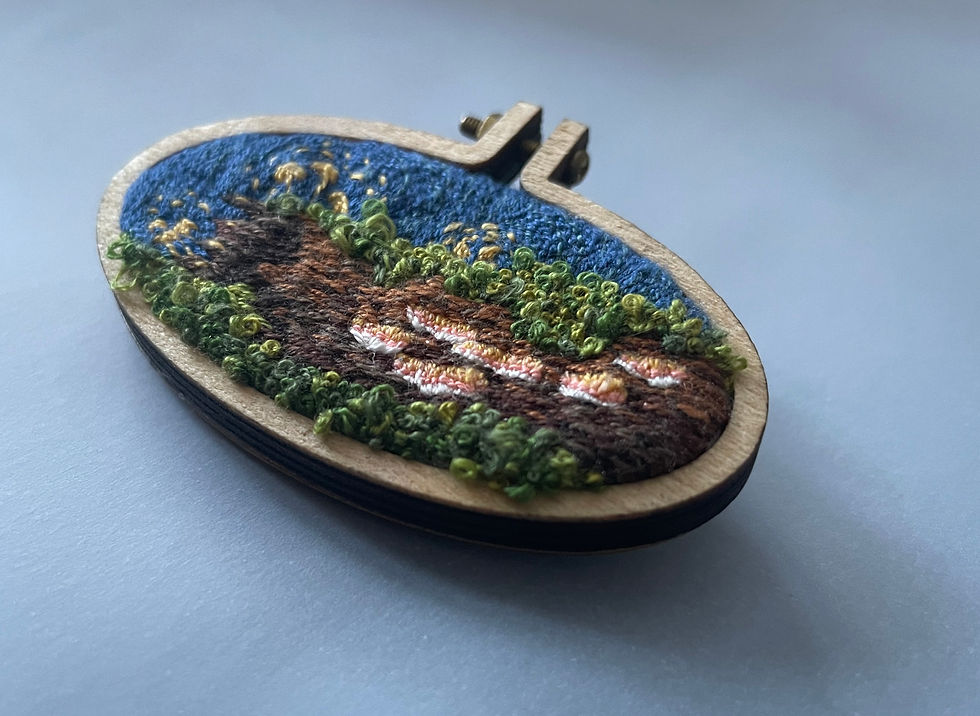 Thumbnail: An embroidered picture of a mossy log with mushrooms held in a small wooden hoop