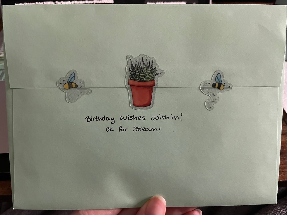 Thumbnail: The back of an envelope with two bee stickers and a succulent holding the flap closed