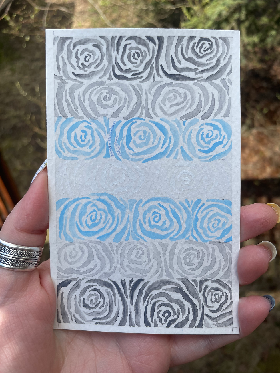 A painting of roses in the colors of the demiboy pride flag