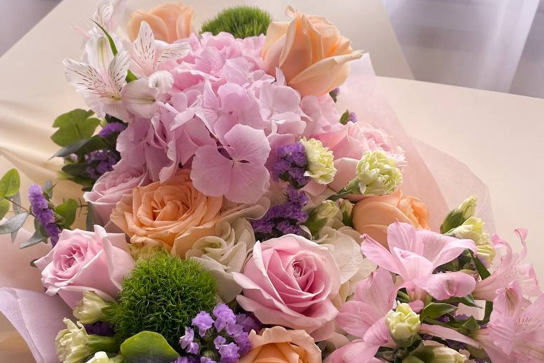 A mix of pink hydrangea, alstroemerias and champagne and pink roses with other foliage and fillers like spray carnations
