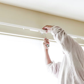 House painter reinstalls a drapery rod RM