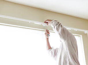 House painter reinstalls a drapery rod RM