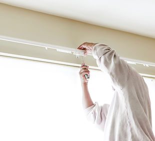 House painter reinstalls a drapery rod RM