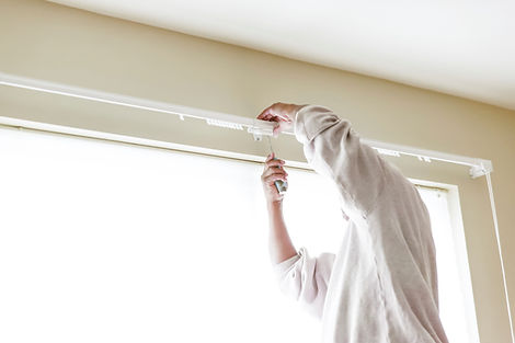 House painter reinstalls a drapery rod RM