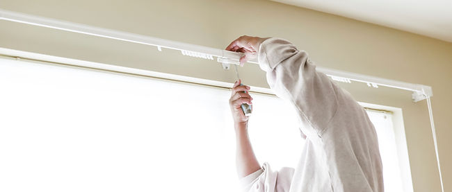 House painter reinstalls a drapery rod RM