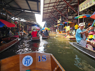 Barcos trafegam em um rio, no Mercado Flutuante da Tailândia.