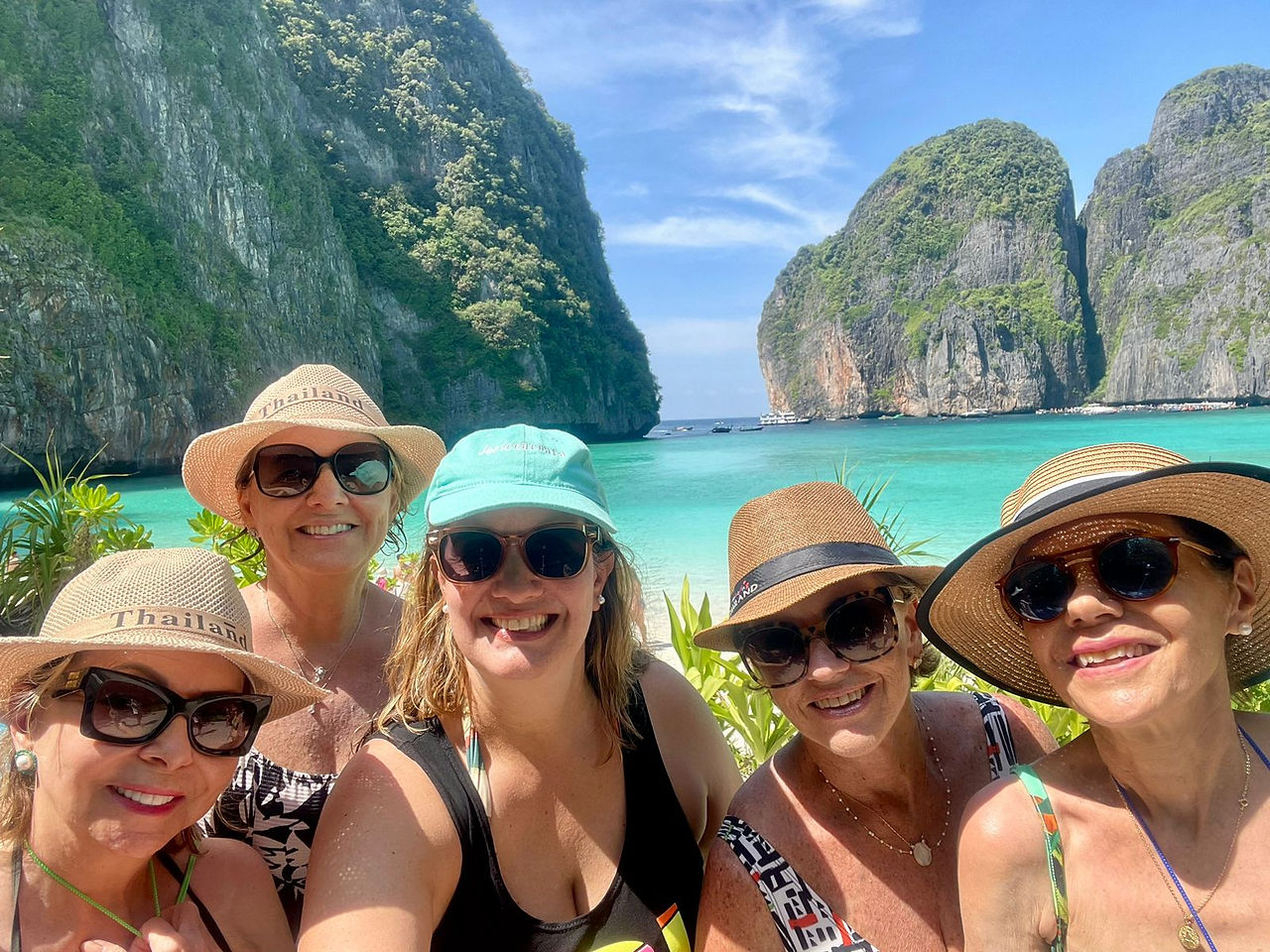 Cinco viajantes posam com o mar de Krabi ao fundo.