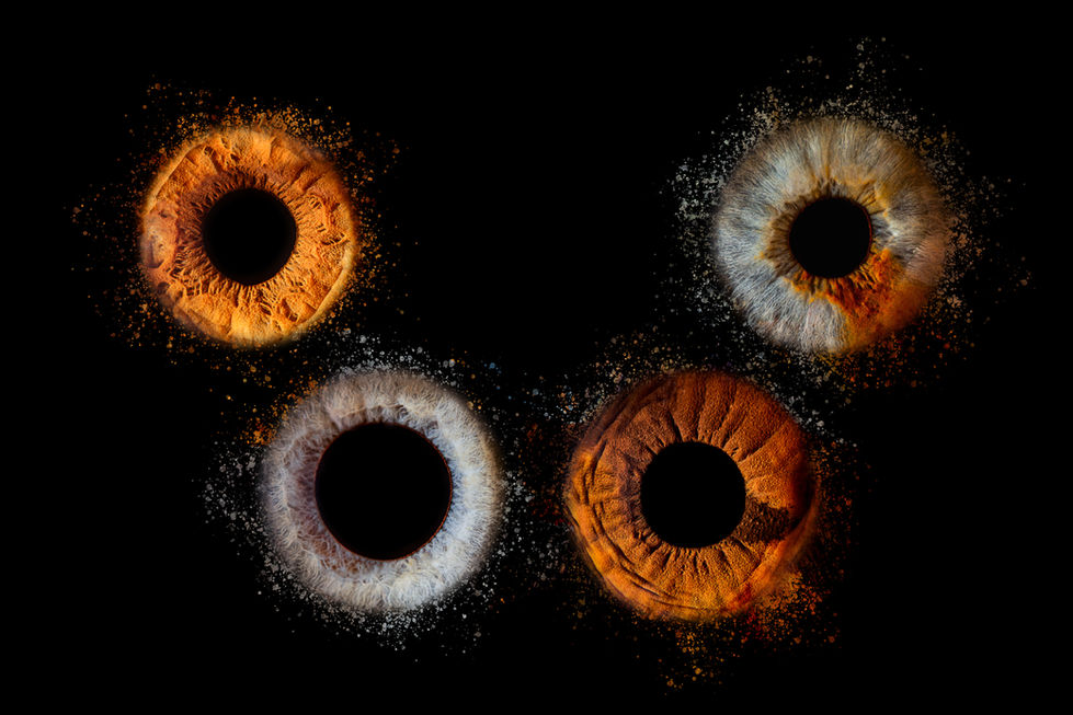 Makroaufnahme mehrerer menschlicher Iriden mit farbigen Pigmentstrukturen auf schwarzem Hintergrund – künstlerische Irisfotografie.