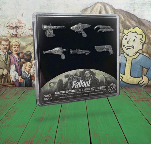a set of 6 pin badges (enamel pins) shaped after iconic weapons from the Fallout series presented in a custom plastic case