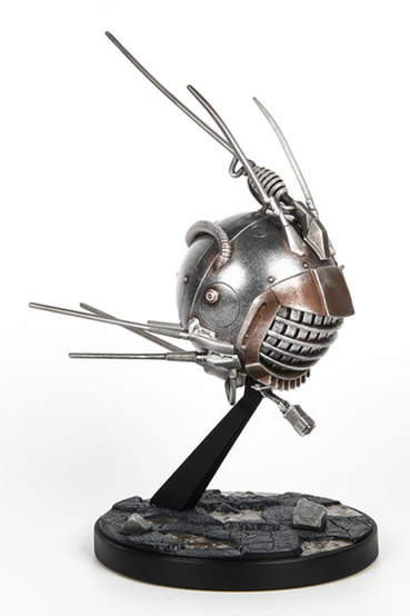an Eyebot from Fallout replica painted in metallic silver with brown weathering detail, attached to a base that looks like broken pavement