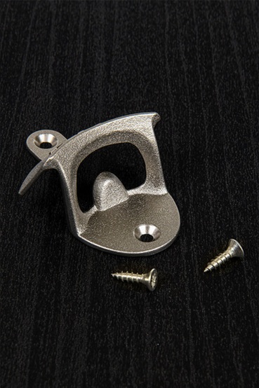 A metal wall bottle opener with the Vault 101 from Fallout 3 vault door gear logo on the front