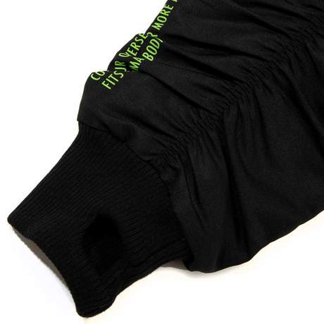 Black tactical bomber with a strap pouch in the back and various zippered compartments on the sleeves and front. Fallout text logo in bright green over the left chest on the front, Vault Boy VATS from Fallout is printed on the back in bright green, embroidered Vault Boy head patch in bright green on the left sleeve, and embroidered Vault-Tec patch on the right sleeve