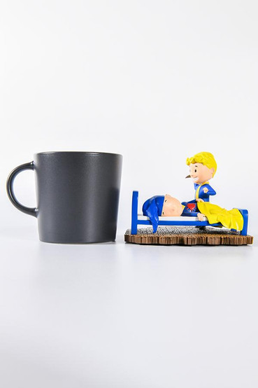 Vault Boy from Fallout mini statues based on various perks from the series, this one is a special variant in technicolor. One Vault Boy is laying in bed with a sleeping cap with a large red stab wound in the middle of his chest, while another Vault Boy is smiling leaning over him with a knife in his right hand