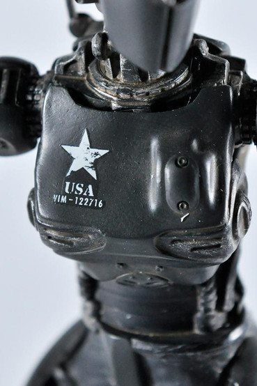 A resin statue based on the Assaultron from Fallout 4 in the black 'Dominator' paint variant with US army markings and a red laser cannon