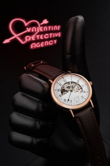 Nick Valentine from Fallout 4 themed wrist watch. The watch has a transparent caseback glass so you can see the inner workings of the watch, a cupid's heart on the watch face, and  matching brown leather bands