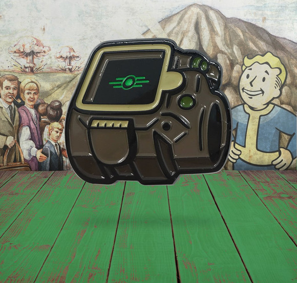 close up of the Pip-Boy from Fallout 4 soft enamel pin with a Vault-Tec themed background