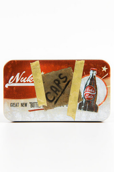 Classic Nuka-Cola from Fallout themed metal tin that comes with 20 matching bottle caps. The front of the tin has a Nuka-Cola advertisement that has the look of a handwritten note that says 'CAPS' taped on front. The loose bottle caps have the Nuka-Cola logo in white printed on red, with the inside of the bottle cap a gold color