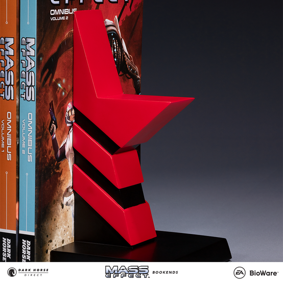 A matching bookend set featuring the morality symbols from Mass Effect: a blue wing for Paragon, and a red star for Renegade, with The Art of the Mass Effect Universe artbook, and both Mass Effect Library Editions Volume 1 and Volume 2 placed in between said bookends