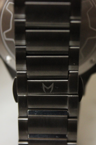 Vault-Tec Administrator from Fallout themed watch by MSTR watches. The watch face resembles a Vault Door with black stainless-steel gear and gold-colored alloy, while the back of the watch has the outline of a Vault Door, 111, and the individual number (limited to 500 units) etched on stainless-steel