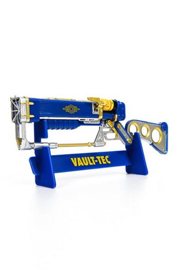 AER9 Laser Rifle from the Fallout series scale replica in a blue and yellow Vault-Tec color scheme with gold and silver accents, placed on top of a matching display stand