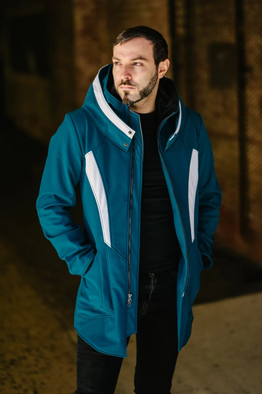 Winter parka by Volante Design, modeled after Garrus Vakarian from Mass Effect. It features a high collar mimicking a Turian's with a spacious hoodie attached, with a Turian Blue outer shell fabric and bold white accents