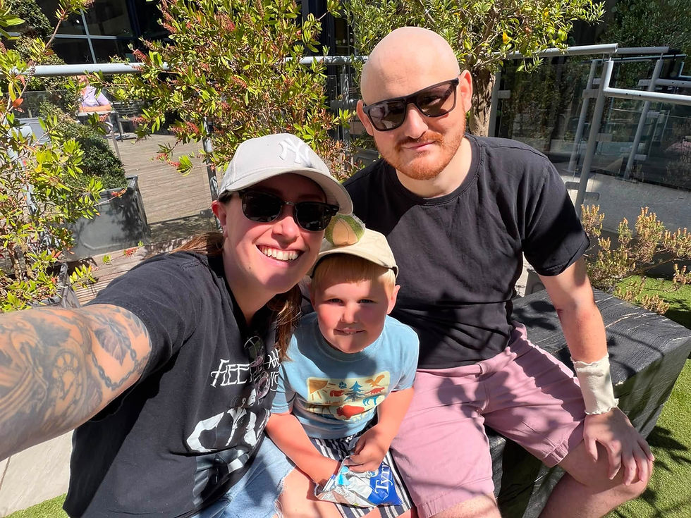 William [right[ with Hannah and son Elijah enjyoing a picnic in the hospital grounds