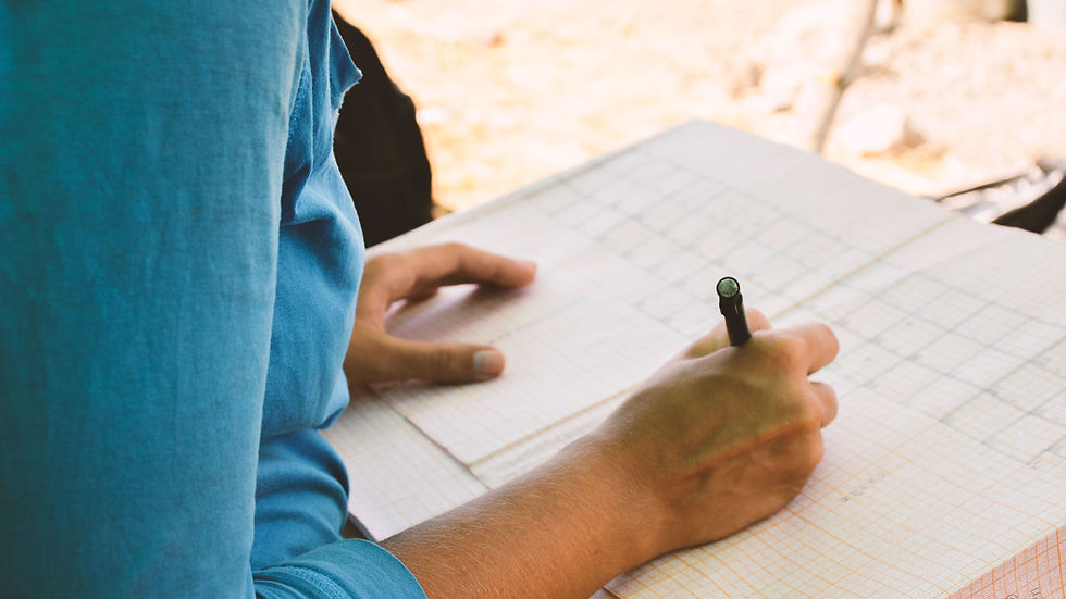 Close-up of a pencil correcting a spelling error on paper. "Diedbure" is underlined in red. Spiral notebook edges visible.