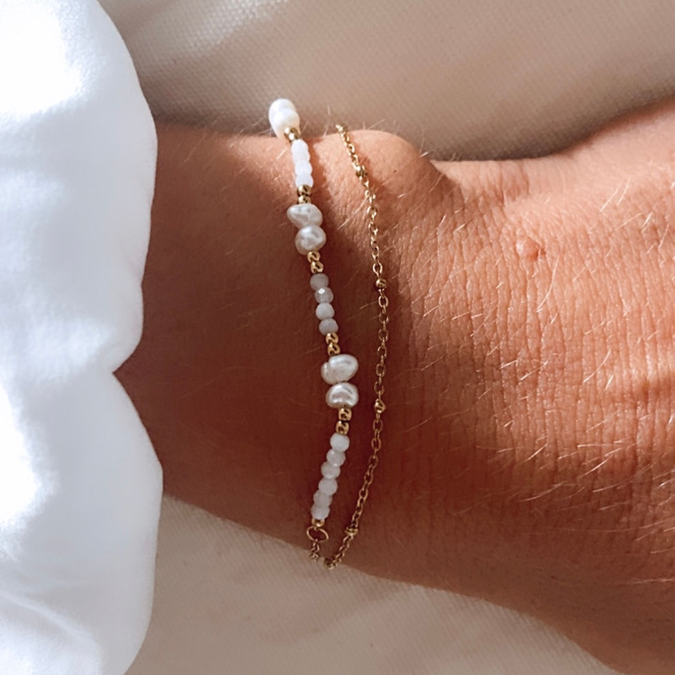 Bracelet composé de 2 chaînes. L'une simple avec des petites billes dorées et l'autre décorée de perles d'eau douce et de nac