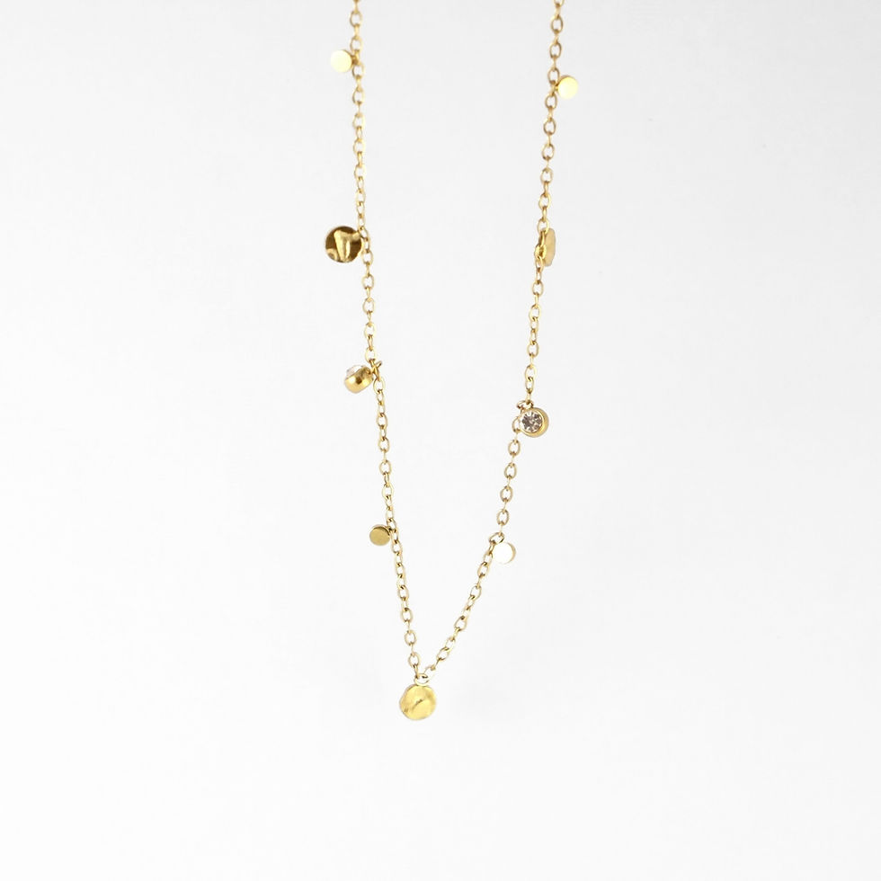 Thumbnail: collier délicat au mouvement léger, ponctué de petites pampilles dorées et d’un détail pierre claire qui capte joliment la lu