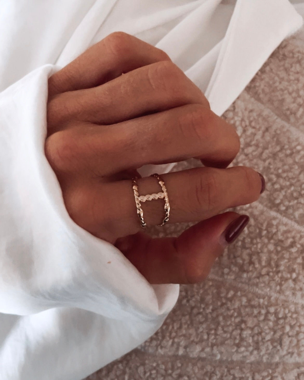 Deux anneaux torsadés reliés par une barre verticale ponctuée de petits strass. Délicate, avec une pointe d’éclat. Note perso